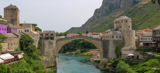 Charming view of Mostar's Old Bridge over the Neretva River, surrounded by medieval buildings.