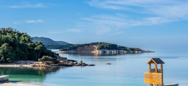 Beautiful beach with clear waters and lush greenery in Ksamil, Albania.